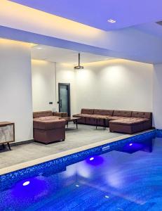 a room with a pool with couches and a swimming pool at The White Suites in Karachi