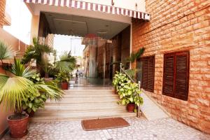 a hallway of a building with potted plants at hotel sandhu palace in Jodhpur