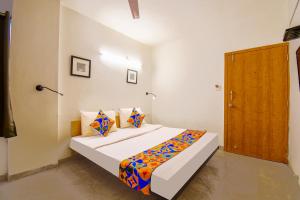 a bedroom with a bed and a wooden door at FabHotel Sai Raj - Nr Zeel College in Pune