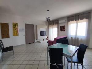 a living room with a glass table and chairs at Case Vacanza Punta Bianca in Agrigento
