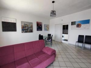a living room with a purple couch and a table at Case Vacanza Punta Bianca in Agrigento