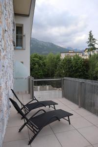 a patio with chairs and tables on a balcony at Apartmán PLÁŇ Vesna Resort in Vysoké Tatry