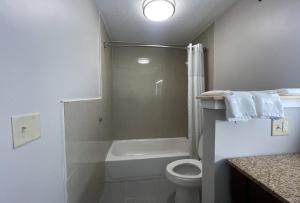 a bathroom with a toilet and a shower and a sink at Days Inn & Suites by Wyndham York in York +41 photos