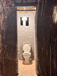 a bathroom with a white toilet in a room at Caves Camp Matrouh in Kafr Abu Habhab