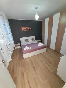 a bedroom with a bed and a wooden floor at Natan Home in Shkodër
