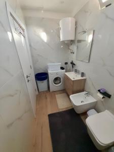 a white bathroom with a sink and a toilet at Natan Home in Shkodër