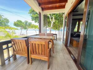 a dining room with a table and chairs on a balcony at Phangan Beachside Villa in Ban Tai