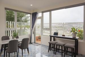 a dining room with a table and chairs and a large window at Hamia - Minh Anh Boutique Hotel in Da Lat