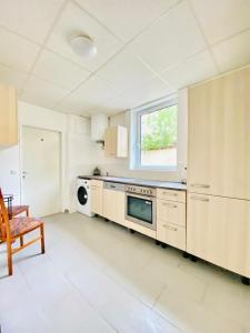 une grande cuisine avec des armoires blanches et une fenêtre dans l'établissement Elegant 3-Bedroom Retreat Convenient City Access, à Vienne