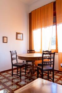 Guest House Emma في Boscotrecase: غرفة طعام بها طاولة وكراسي ونافذة