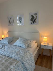 a bedroom with a bed and a nightstand with two lamps at Apartmán Wendy in Nové Město na Moravě