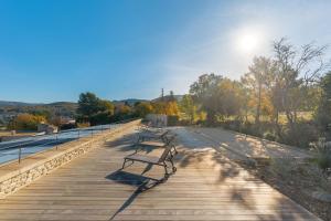 a row of benches sitting on a boardwalk at Tiny House APT in Apt