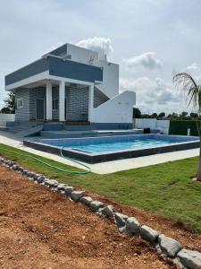 a house with a swimming pool in front of it at DRZ Farm Stay with Private Pool 2BR by Homeyhuts 