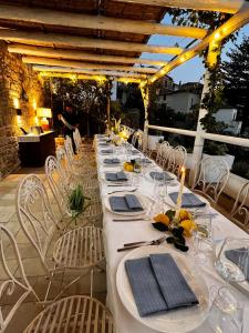 a long table with white tables and chairs on a patio at Punta Fortino Resort in Agropoli