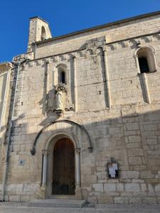 a stone building with a door with a statue above it at Heaven Chambres chez l'habitant in Valergues +1 photo