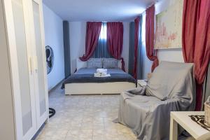 a small bedroom with a bed and a chair at Mitro Seaview Apartments in Nea Vrasna