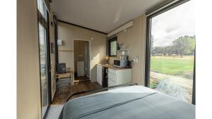a bedroom with a bed and a large window at Matakanui Retreat 1 by Tiny Away in Omakau