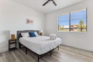 グレンデールにあるCozySuites Glendale - Westgate w pool 16のベッドと窓のある白い寝室