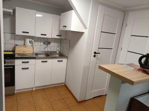 a kitchen with white cabinets and a sink at Gospodarstwo Agroturystyczne na Mazurach in Jerutki