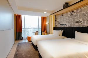 广州Arthur Hotel Baiyun Guangzhou的有两张床和一扇窗户的酒店房间