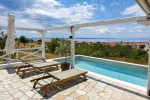 a patio with two chairs and a swimming pool at Barn Villa in Nikiti