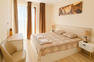 a bedroom with a bed and a chair in it at Poseidon Nessebar Private Apartment in Nesebar
