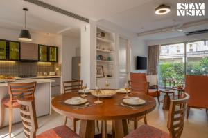 Una cocina y un comedor con mesa y sillas. en StayVista at Casa Vida Zen with BBQ, Pool, WiFi, en Vagator