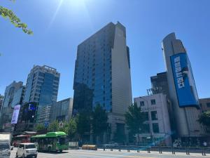 首尔Hongdae apartment 1min subway ChaCha Stay的一辆巴士开往城市街道,街道上有许多高大的建筑