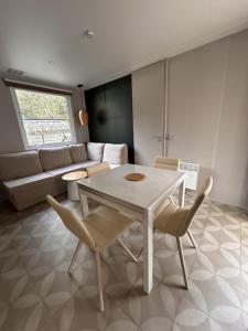 a living room with a white table and chairs at Le Domaine des Pins in Saint-Hilaire-de-Riez