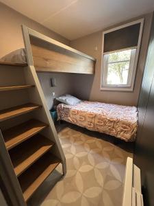 a bedroom with a bunk bed and a bunk ladder at Le Domaine des Pins in Saint-Hilaire-de-Riez