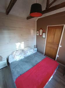 una camera da letto con un letto grande con una coperta rossa di Au Marais ad Amiens