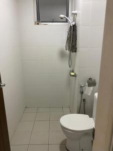a white bathroom with a toilet and a window at Chez Marcel in Tanjung Bungah