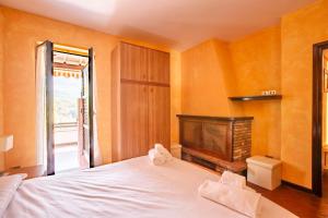 - une chambre avec un lit blanc et une cheminée dans l'établissement La Dimora del Tasso - Garden, Terrace & Mountain View, à Carlazzo