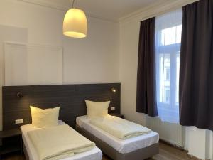 ein Schlafzimmer mit zwei Betten und einem Fenster in der Unterkunft Ferienwohnungen Neumann in Bamberg + 40 Fotos
