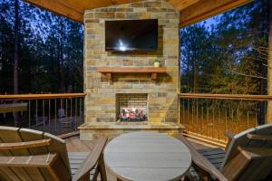 a screened in porch with a fireplace and a tv at NEW Woodland Escape with Spa & Fire pit - Sleeps 4 in Mount Herman