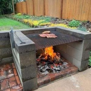 a barbecue grill with a fire in a backyard at Sky resort ajk patikka in Muzaffarabad