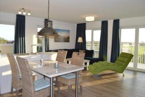 a kitchen and living room with a table and chairs at Komfortwohnung mit Weitblick in Schillig +9 photos