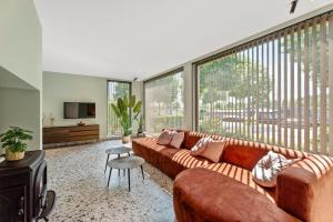 a living room with a couch and a large window at Villa Couleur in Diksmuide
