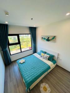 Un dormitorio con una cama con sábanas azules y una ventana. en AN HOME 1BR Near Vincom Mall 0314, en Long Bình 5 fotos más
