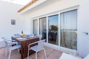 une salle à manger avec une table et des chaises et un balcon dans l'établissement CoolHouses Algarve Luz, 3 Bed Townhouse w/ beautiful sea view, Luz Bay 76, à Luz