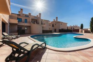 una piscina con sedie e una casa di CoolHouses Algarve, Luz 2 bed elegant flat, private pool & garden, SPA facilities, Mar da Luz 19 a Luz