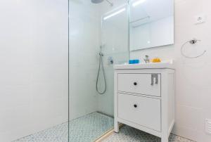 une salle de bain blanche avec une douche et un lavabo dans l'établissement CoolHouses Algarve Luz, 3 Bed Townhouse w/ beautiful sea view, Luz Bay 76, à Luz 19 autres photos