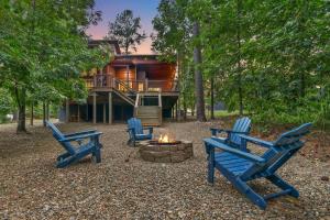 Cabin Retreat with Spa Fire Pit & Games - Sleeps 4 في بروكن بو: مجموعة من الكراسي الزرقاء تجلس أمام المنزل
