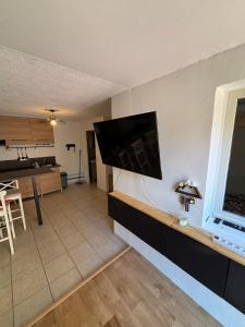 a living room with a flat screen tv on a wall at Appart proche du lac et plages in Soustons