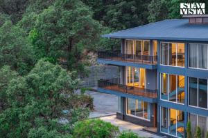 une vue aérienne sur une maison avec un bleu dans l'établissement StayVista at Glass Forest with Bonfire, BBQ, à Mussoorie