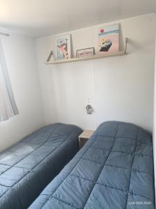 a bedroom with a blue bed and a shelf at Camping les sablines 129 à vendres-plage in Vendres