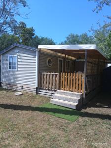 a small house with a porch and a deck at Camping les sablines 129 à vendres-plage in Vendres