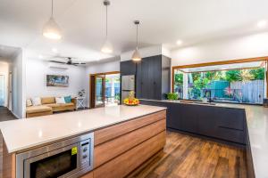 an open kitchen and living room with a couch at Clifton Cove Cairns Paradise in Clifton Beach