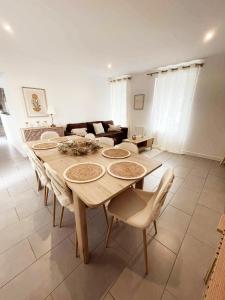 a living room with a wooden table and chairs at La Maison de Mélou in Troarn