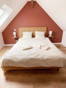 a bedroom with a large bed with two towels on it at La Maison de Mélou in Troarn